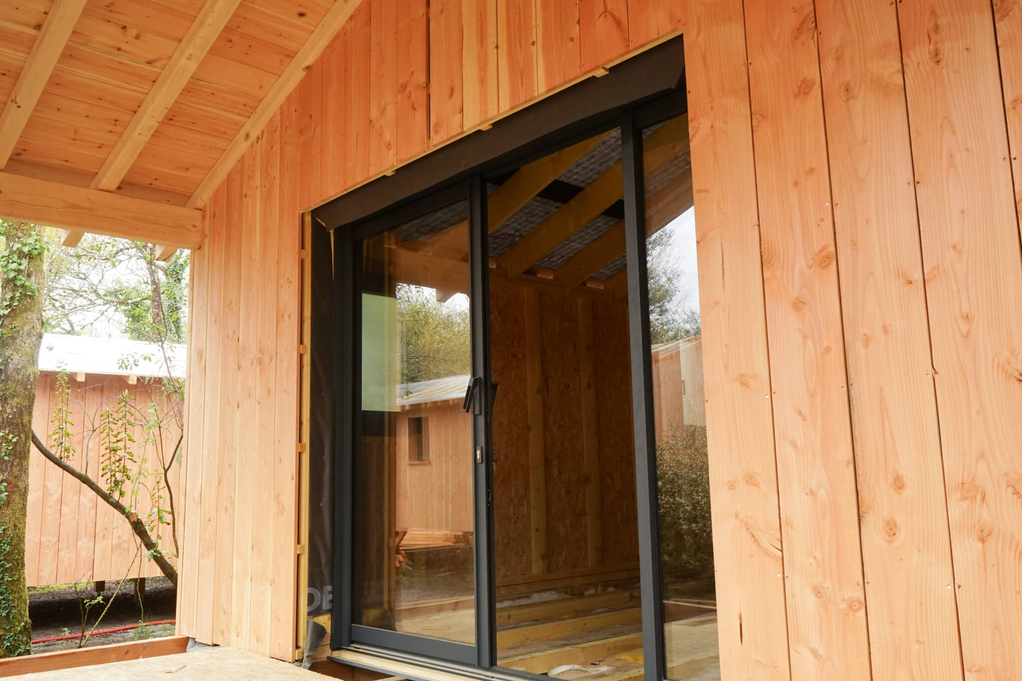 Baies vitrées alu et fenêtres PVC noires pour les cabanes du Marache à Biganos