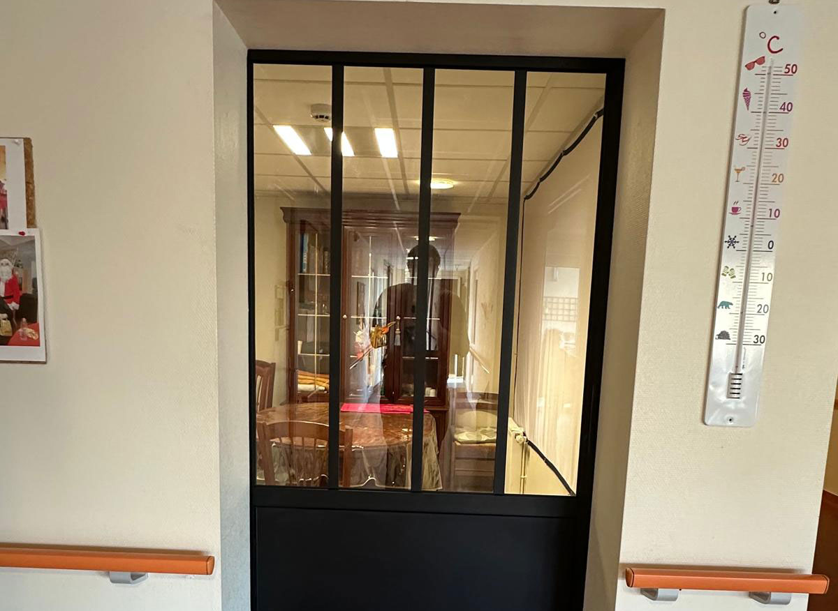 Chantier en EHPAD : Pose d'une porte style verrière pour une salle des familles